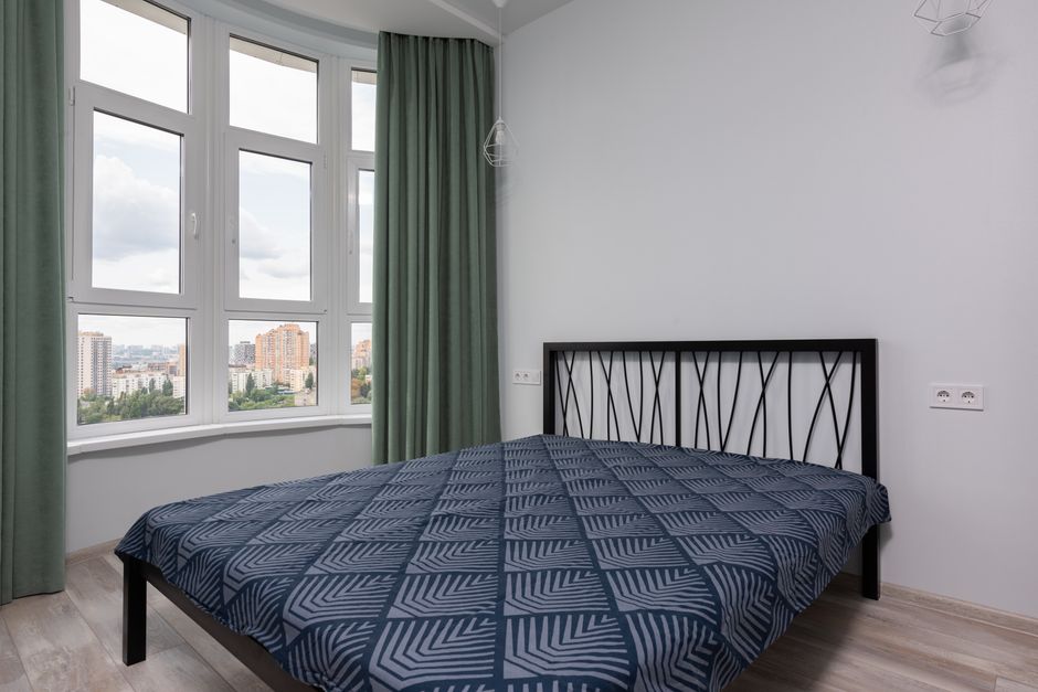 bedroom with floor-to-ceiling curtains styled for a rental apartment