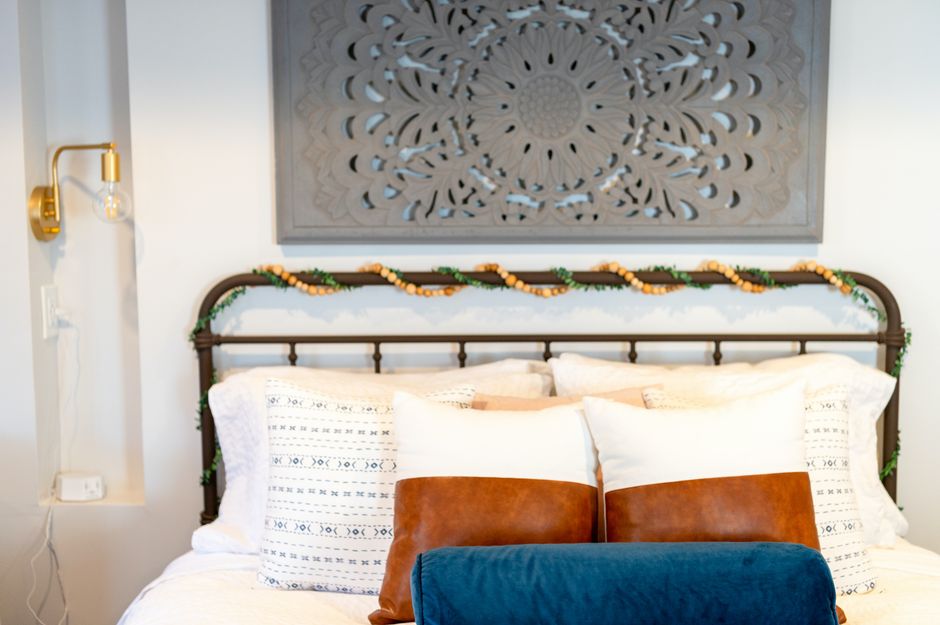 A bed with cozy, layered neutral bedding and stacked pillows