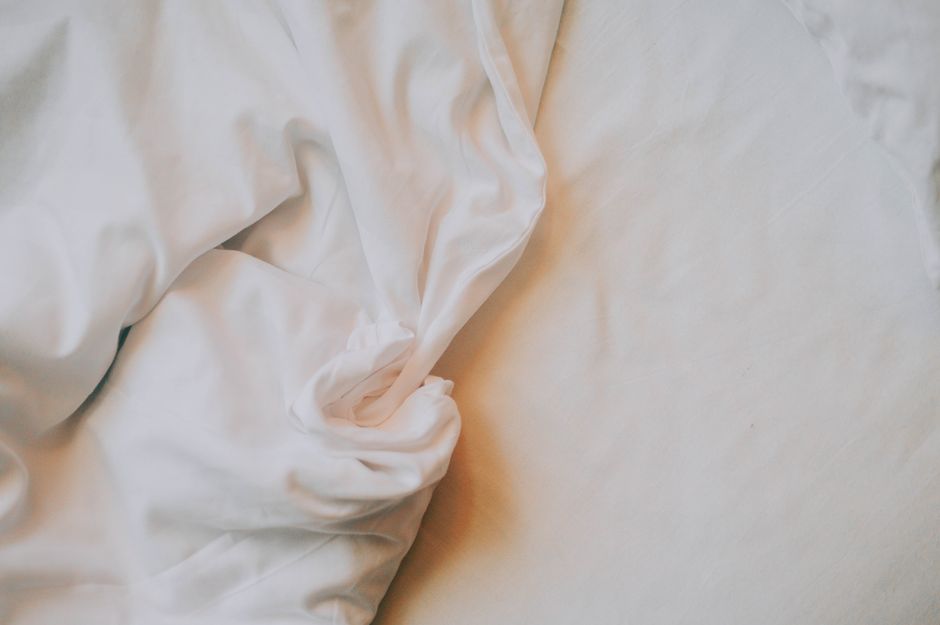Crisp folded cotton sheets in neutral tones
