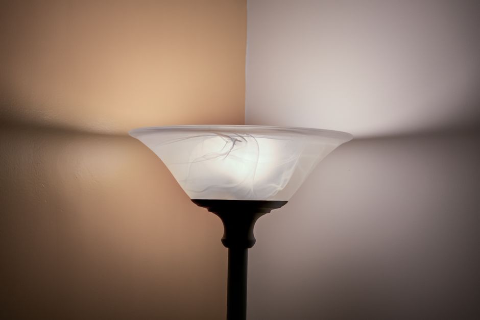 A floor lamp casting warm light in a cozy living room corner