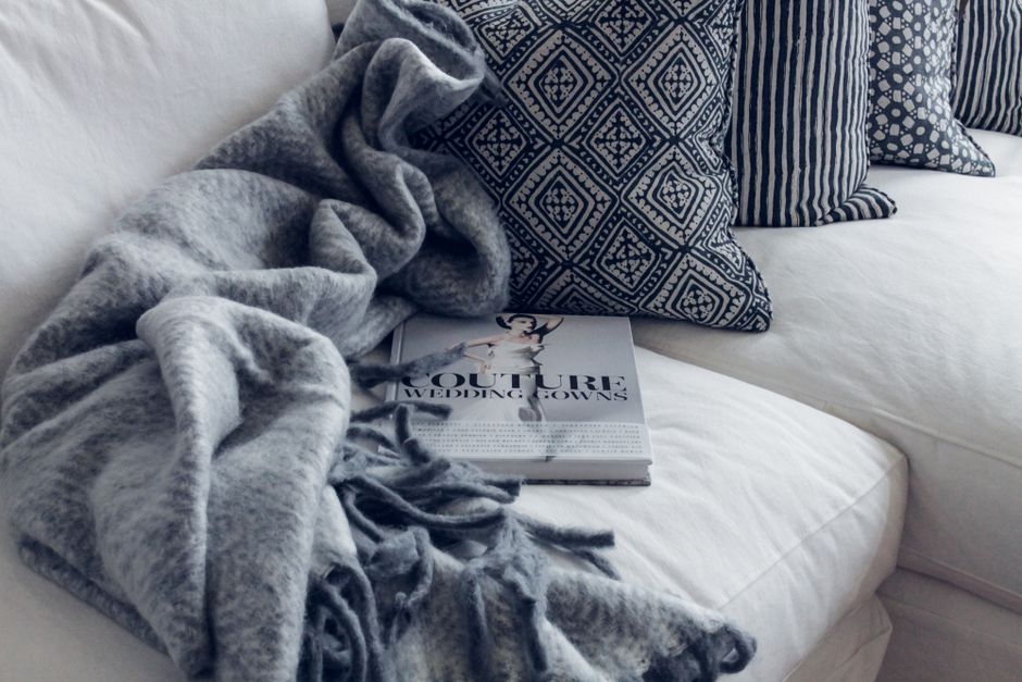 A warm, layered living room with a throw blanket and cushions