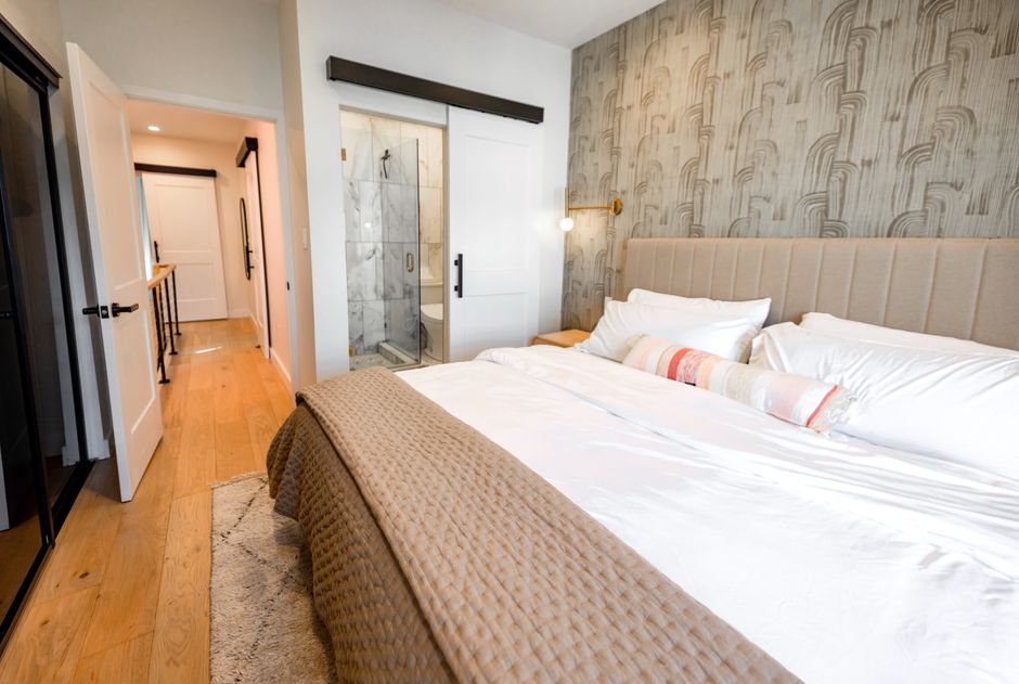 A hotel-style bedroom with crisp, layered bedding