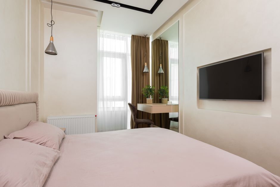 Large decorative mirror reflecting light in small bedroom
