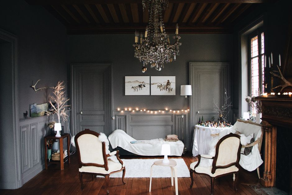 A cozy living room with warm lamplight, a throw blanket, and candles