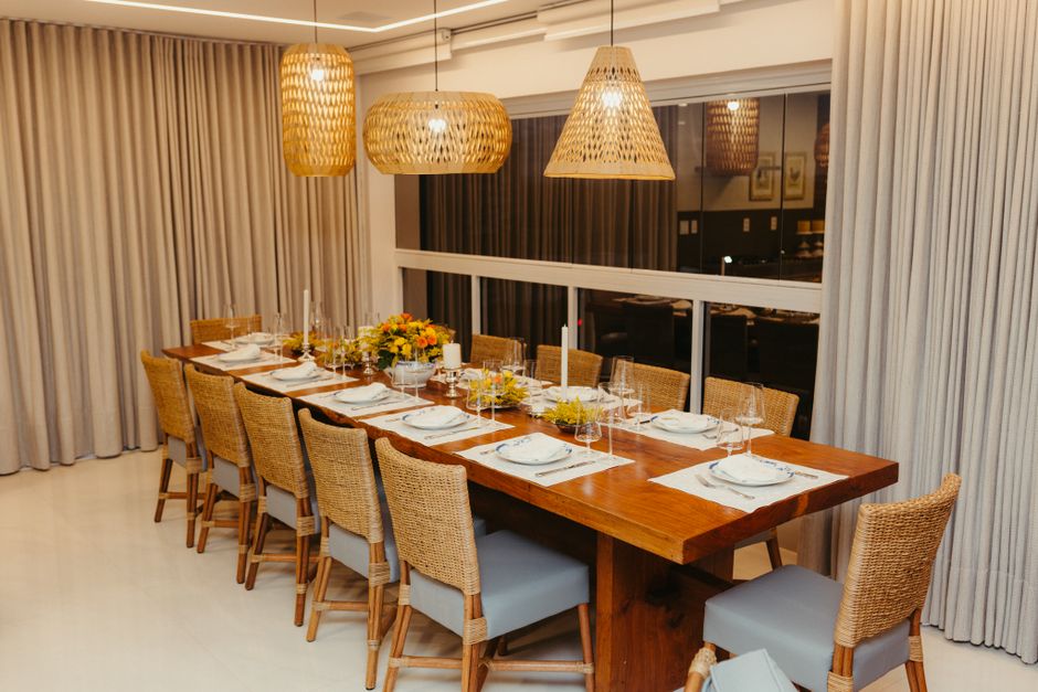 Stylish dining room with wicker chairs and pendant lights, ready for a dinner party.