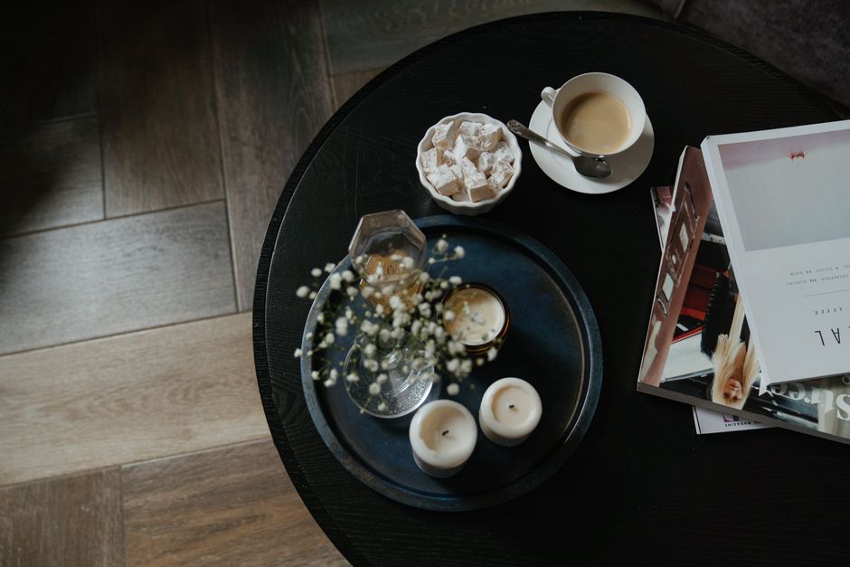 A coffee table styled with books, a tray, and a candle