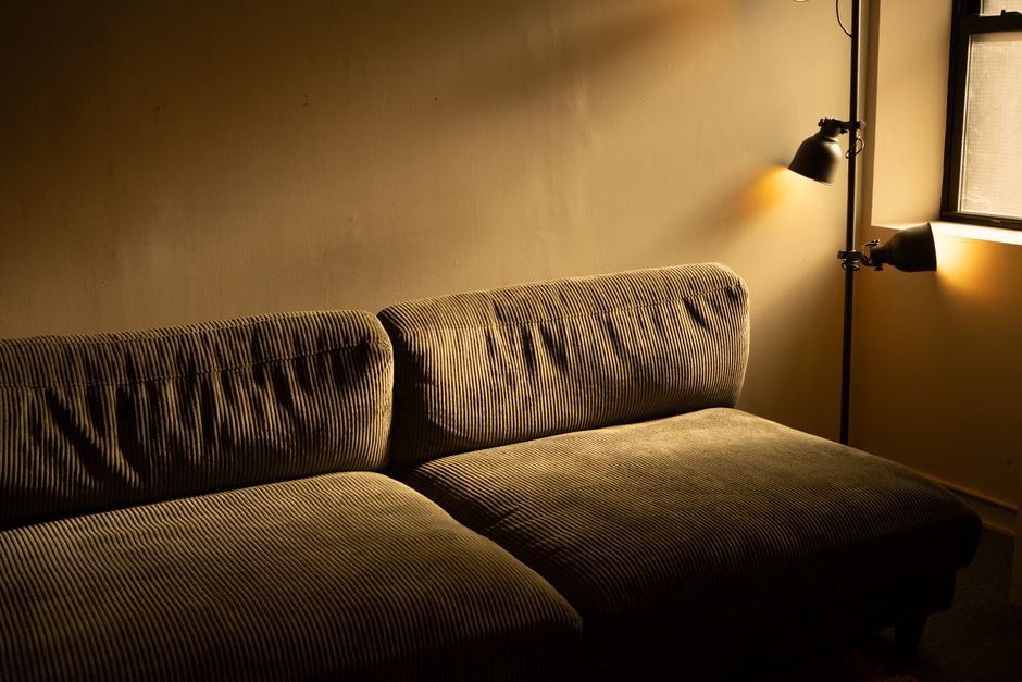 A warmly lit living room in the evening with a glowing floor lamp and soft ambient light