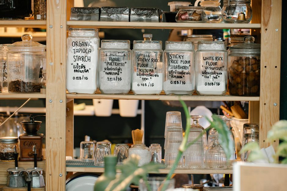An organized pantry with labeled jars and baskets