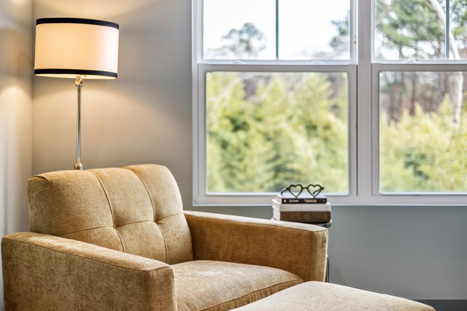 velvet armchair reading corner with books and cozy throw blanket