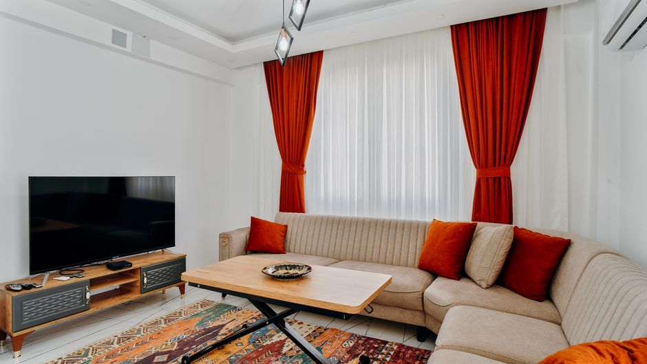 Compact living room with small sectional sofa and light-colored walls