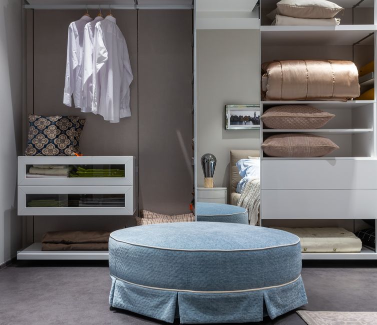 Organized bedroom closet with folded clothes and storage bins