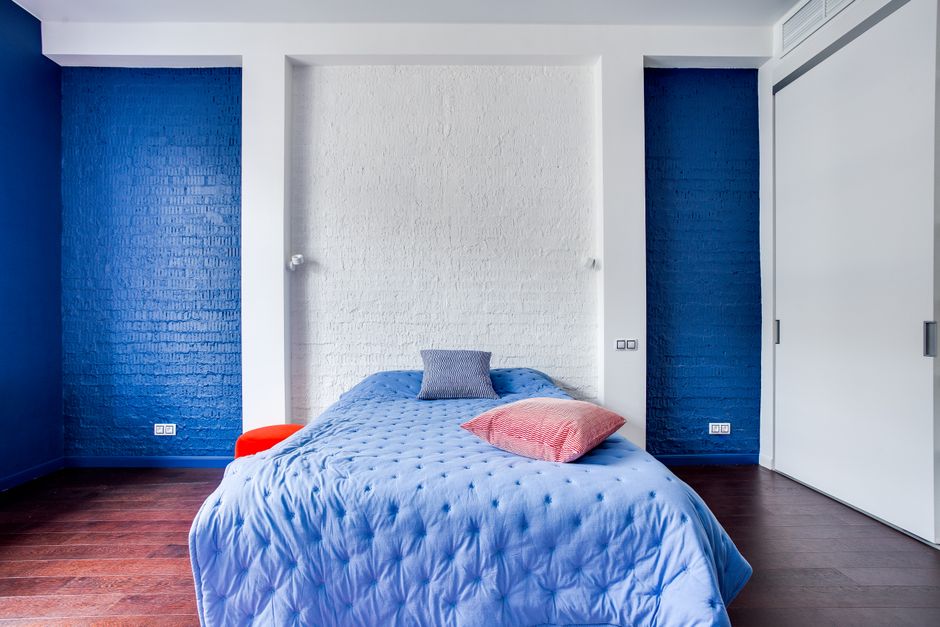 Dark accent wall behind bed frame with matching neutral decor