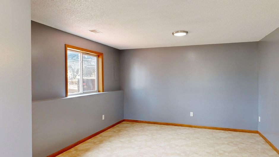 Bright and empty modern room with gray walls and natural light.