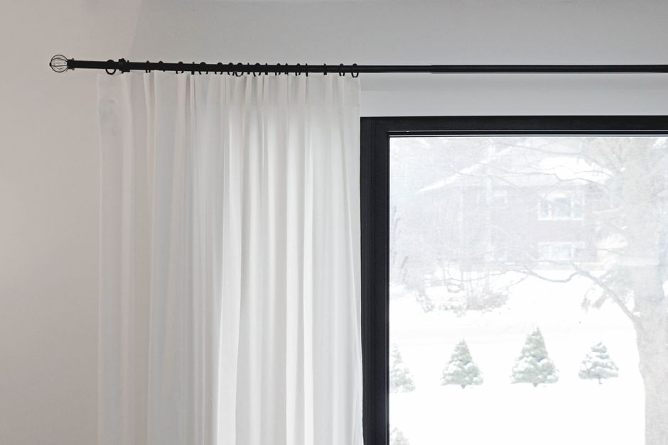 Curtain rod mounted high above a window frame to make the ceiling look taller
