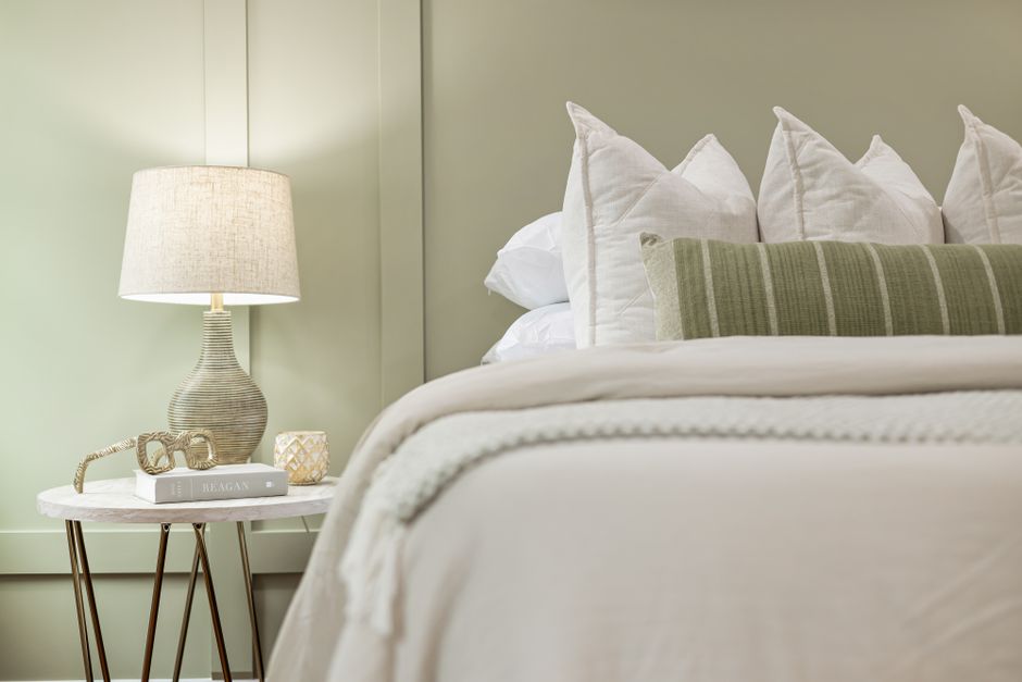 Nightstand styled with a lamp, small stack of books, and a ceramic tray