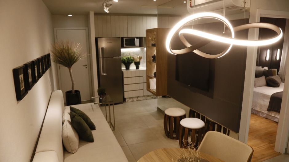 a small apartment living room styled with light furniture and warm lighting