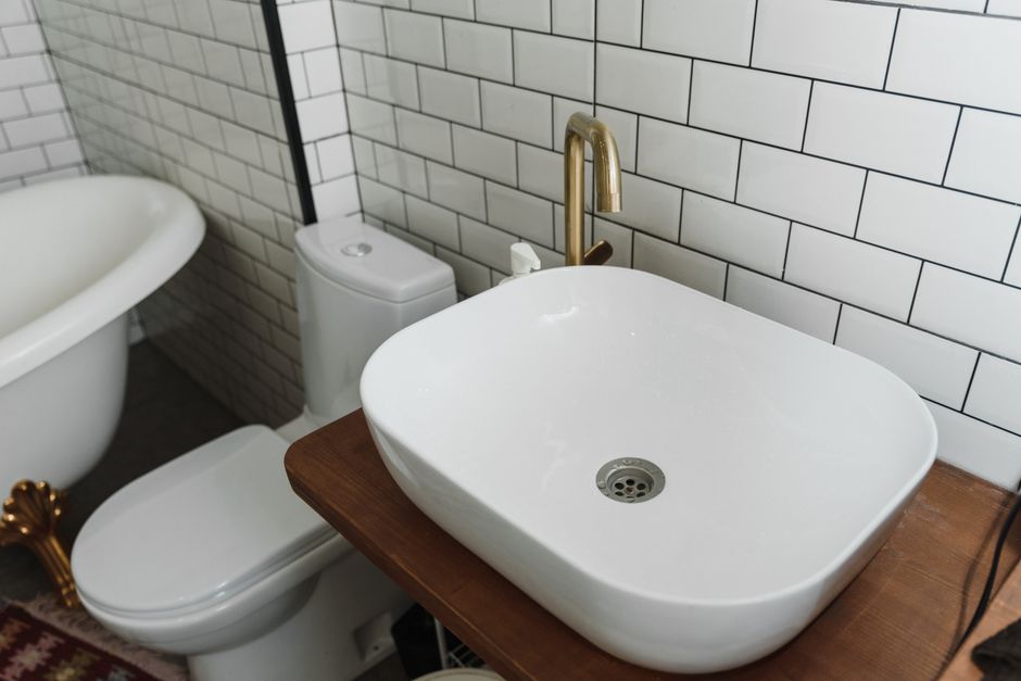 bright small bathroom with vanity mirror and plants