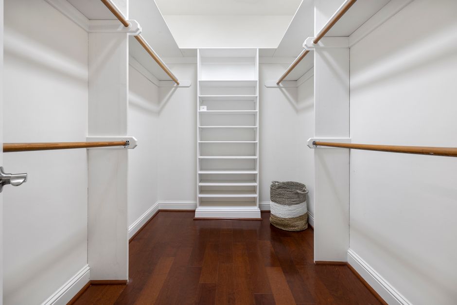 Small closet organized with double hanging rods and labeled bins