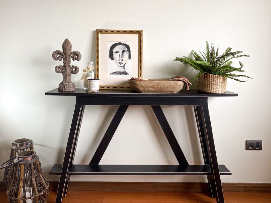 Hallway with a gallery wall of mixed frame sizes above a slim console table
