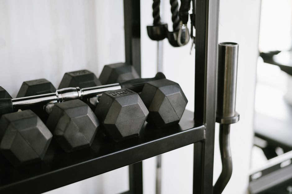 Wall-mounted dumbbell rack keeping the floor clear in a compact home gym