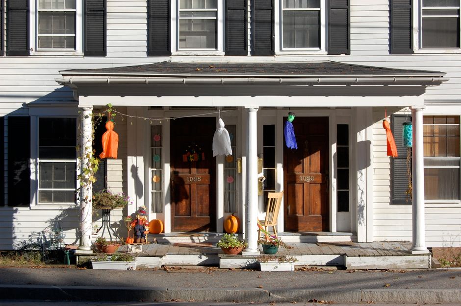 Small front porch decorated with a chair, plants, and a welcome mat