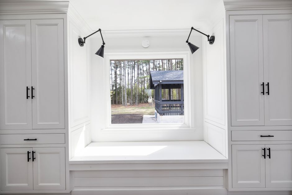 Window bench with woven storage baskets tucked beneath a cushioned seat